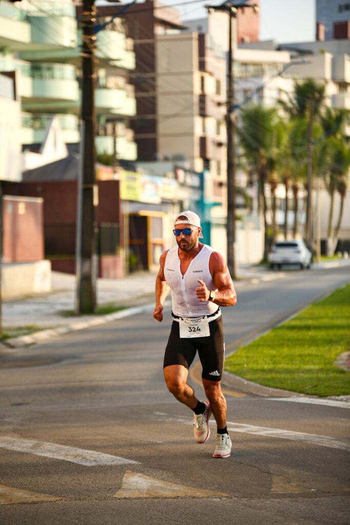 Male athlete in sportswear running on city street during a marathon.